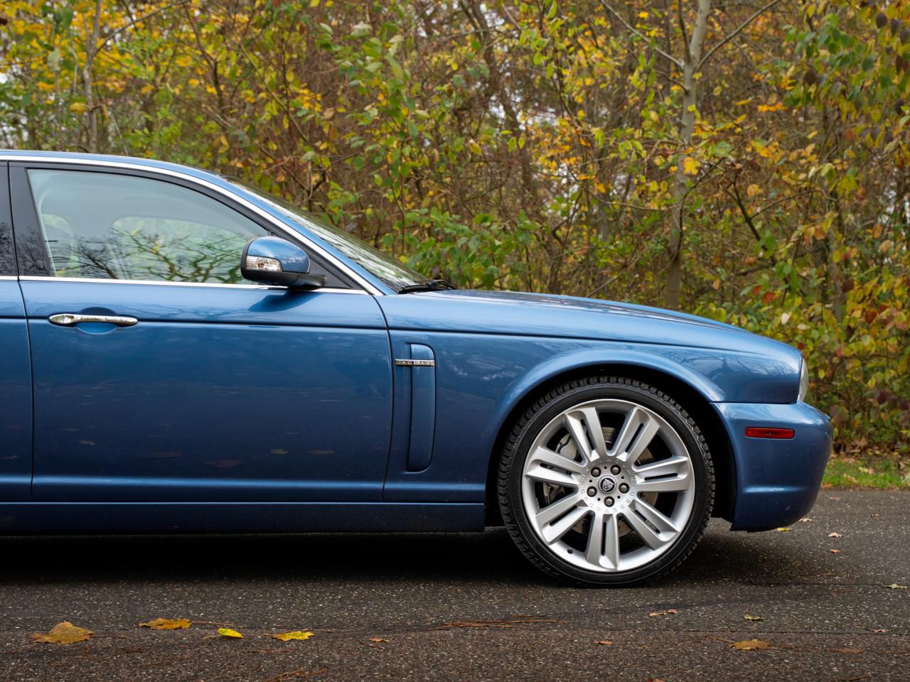 Jaguar XJ achterzijde 3/4 met herfstkleuren
